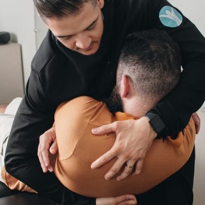 Quiropraxista realizando ajuste na coluna de paciente em clínica de Montes Claros